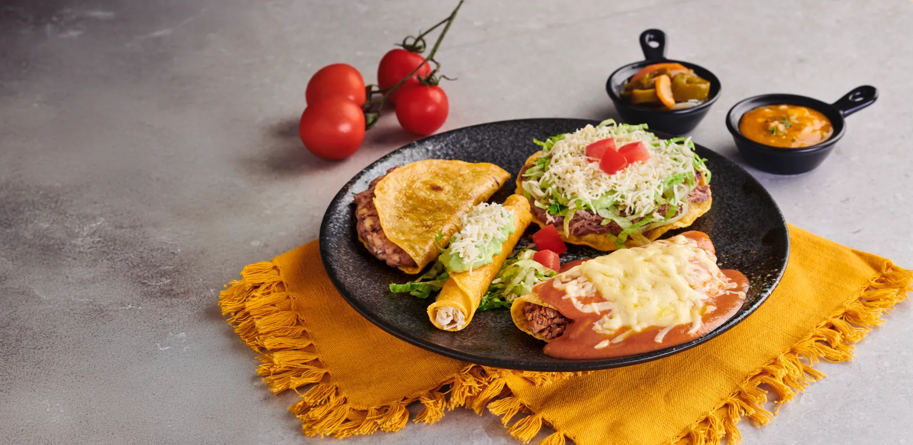 Platos mexicanos de Taconazo sobre mantel amarillo
